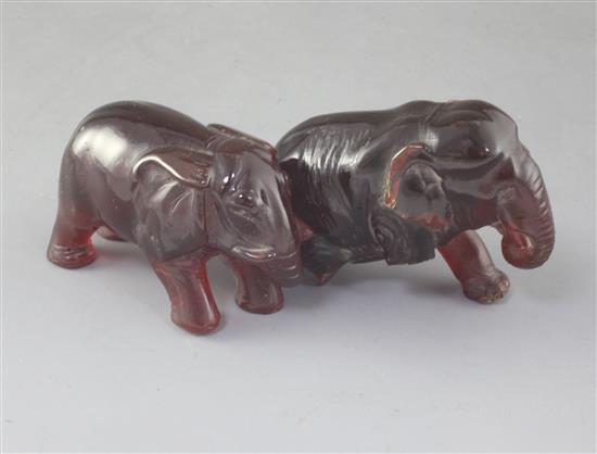 Two natural cherry amber figures of elephants, late 19th/early 20th century, gross weight 275g, one elephant with losses